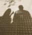 Silhouettes of two people cast in shadow on a gridded surface