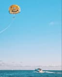 Kite flying over the ocean with a boat on the water